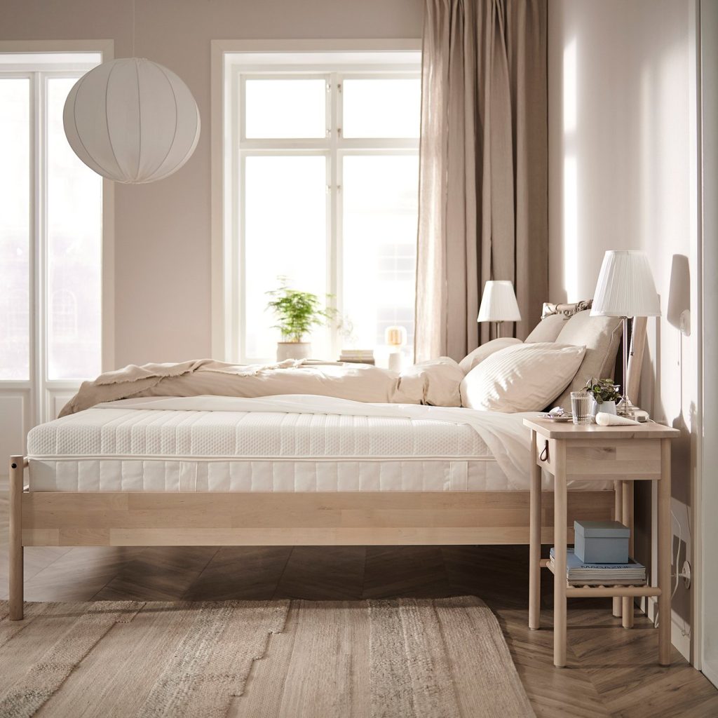 IKEA ÅNNELAND numa cama de madeira clara num quarto luminoso