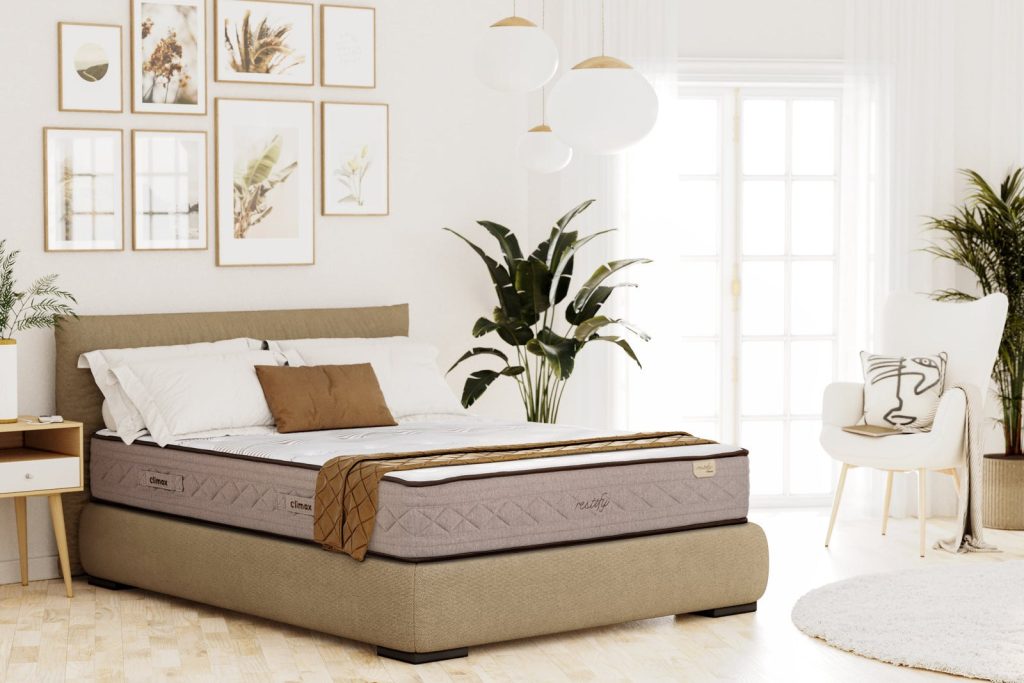 Colchão Climax Restify numa cama estofada com plantas