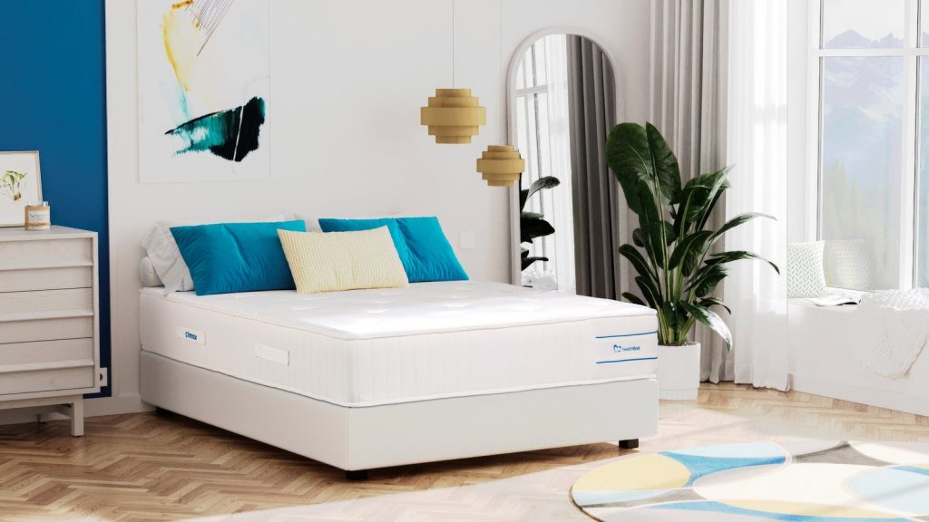 Colchão Climax Saúde num quarto com almofadas azuis