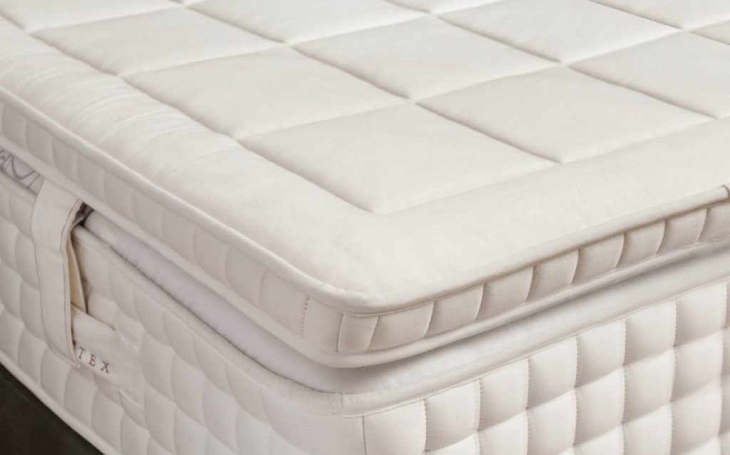 Dunlopillo Advance Natural Topper sobre um colchão, pormenor do canto com duplo debrum
