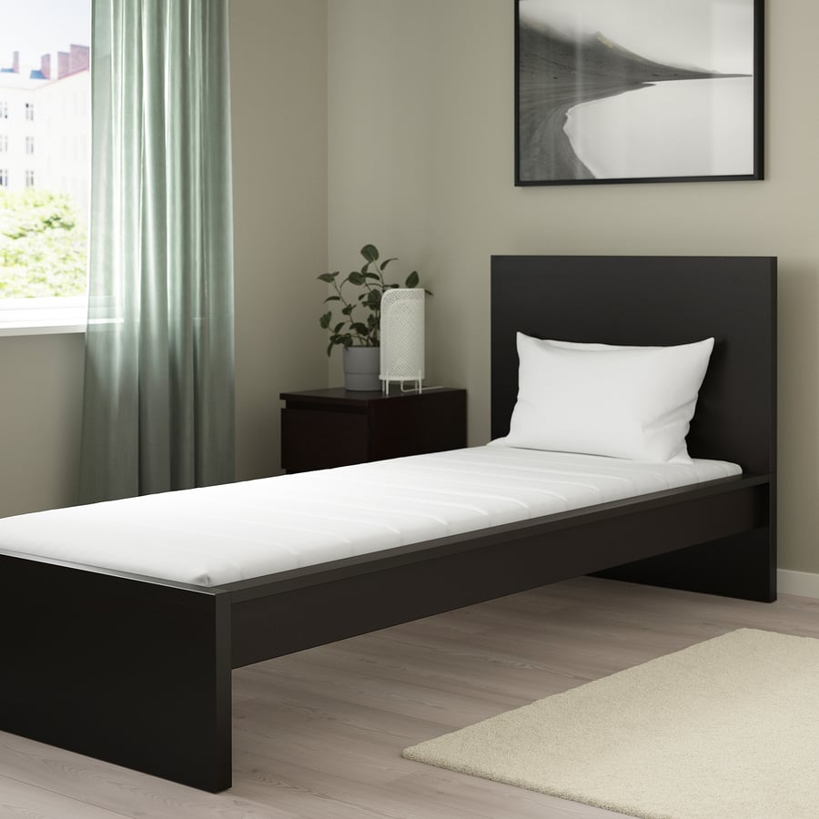 Colchão IKEA ÅFJÄLL numa cama de solteiro escura