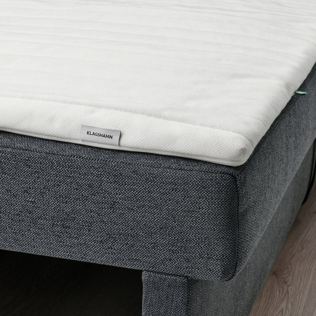 IKEA KLAGSHAMN colocado sobre um sofá-cama cinzento escuro, com a etiqueta à vista