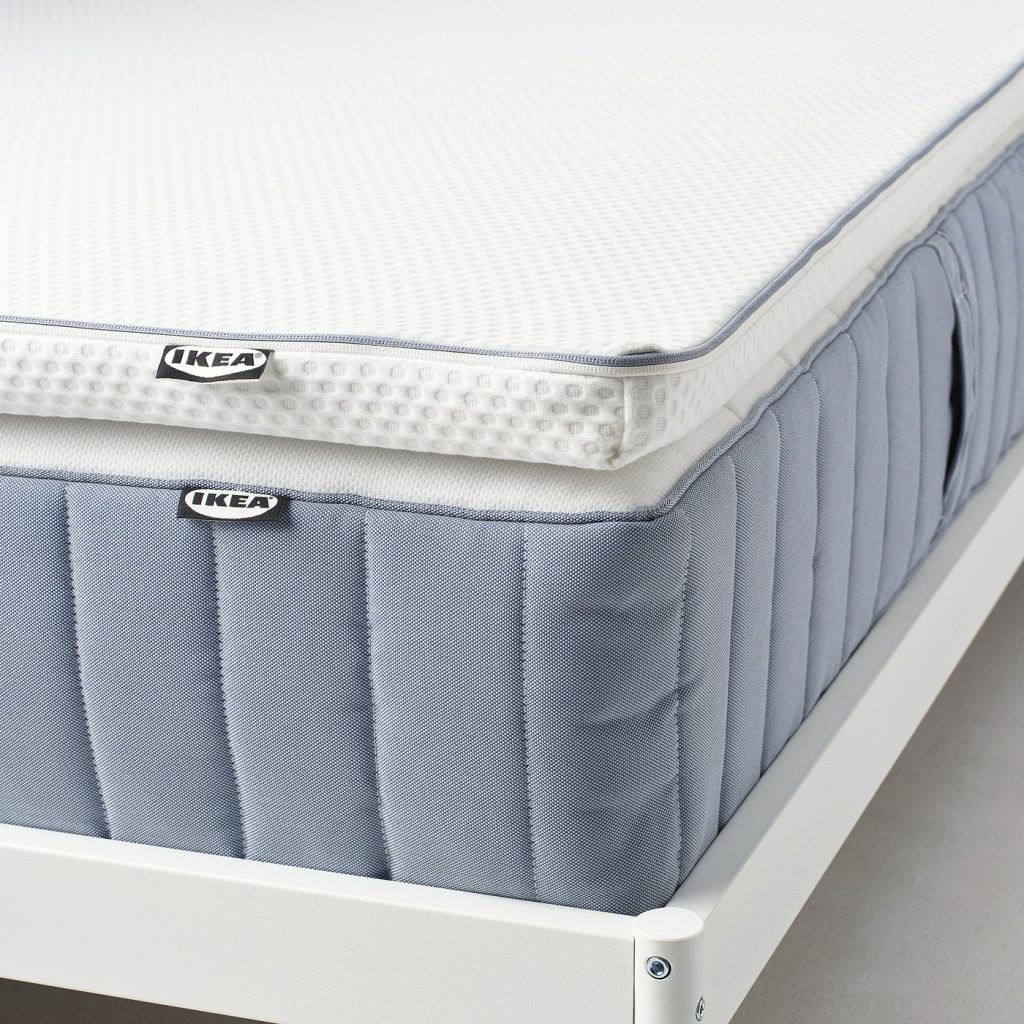 IKEA NÄSTABERG colocado sobre um colchão de molas azul numa estrutura branca