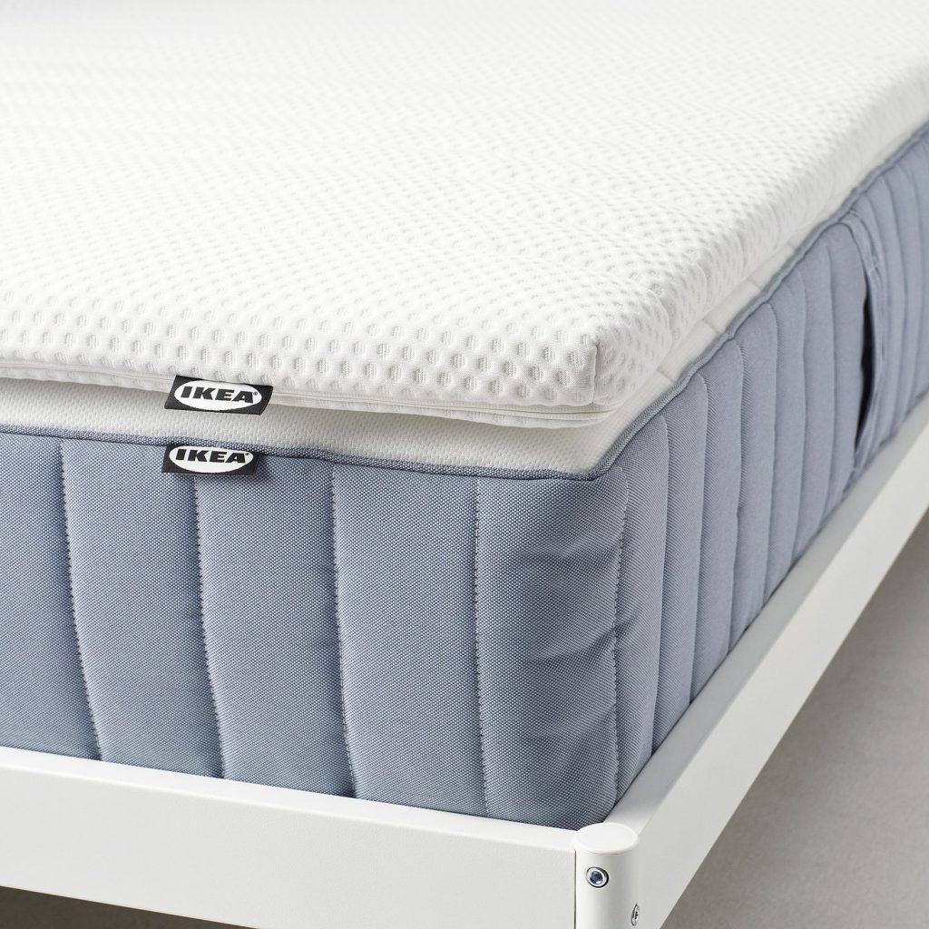 IKEA NISSEHOLM colocado sobre um colchão de molas azul numa estrutura branca