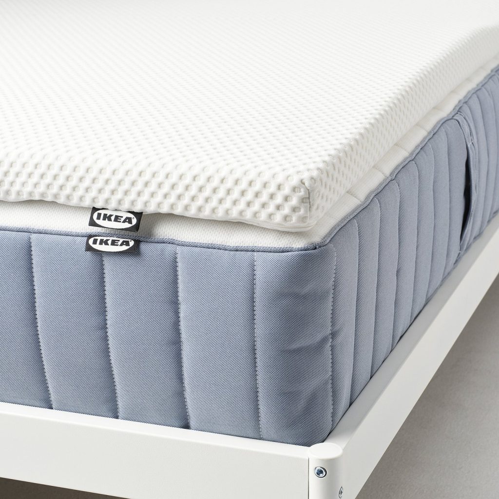 IKEA NORDBERGET colocado sobre um colchão de molas azul numa estrutura branca