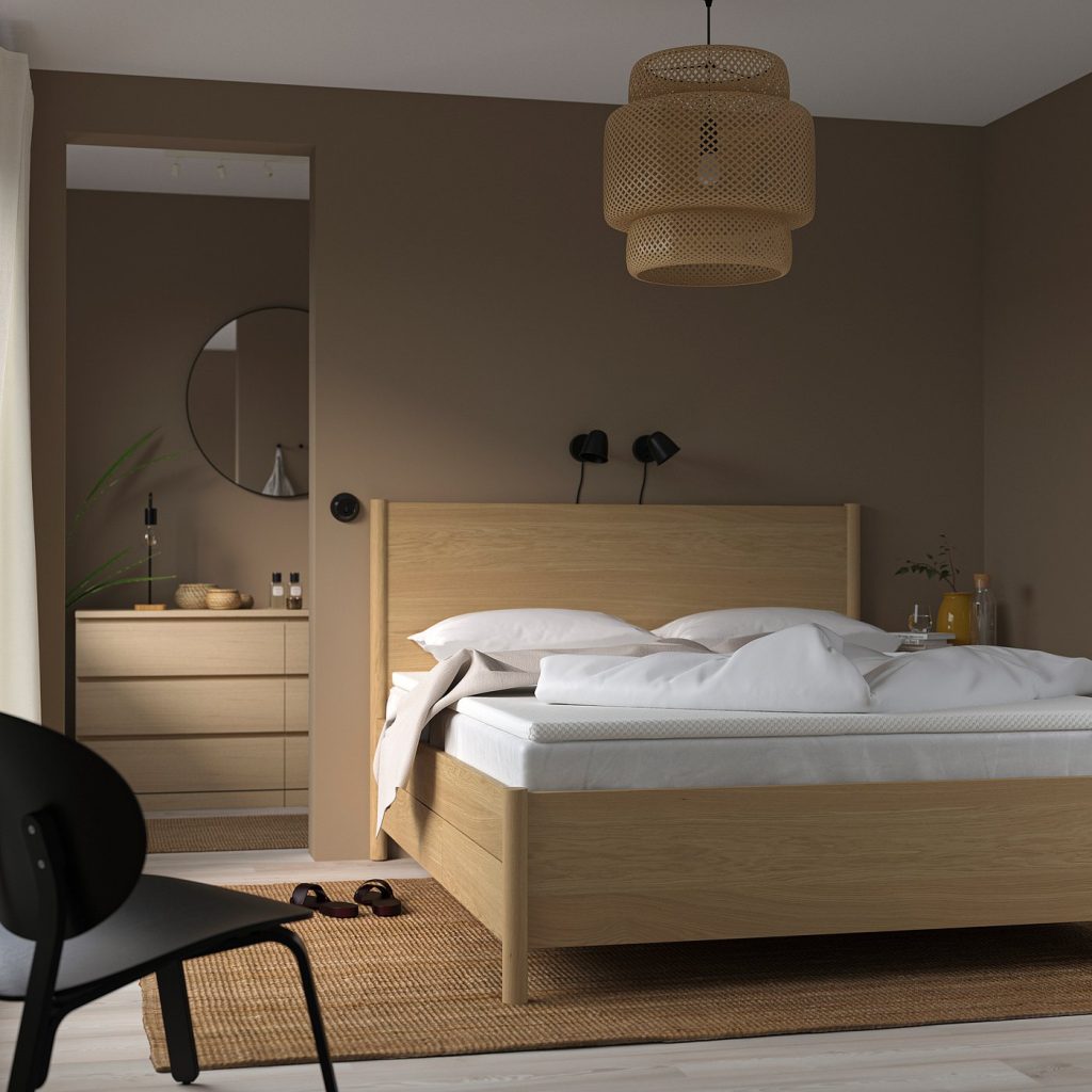 IKEA NORDBERGET numa cama de madeira clara num quarto de tons quentes
