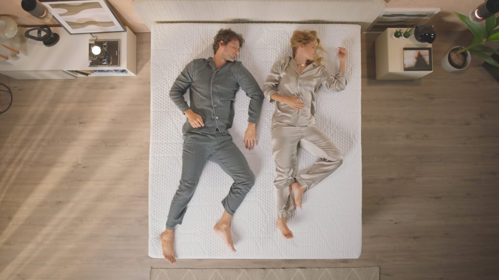 Casal deitado de costas no Sobrecolchão Emma Elite, visto de cima