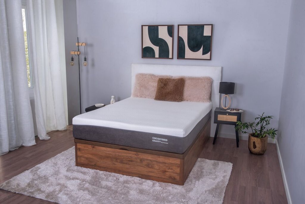 Colchão Somnalis Cocohybrid Gravity numa cama com gaveta de madeira
