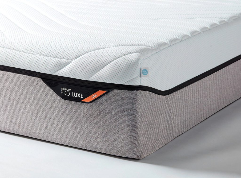 Colchão Tempur PRO Luxe CoolQuilt, canto com a etiqueta PRO LUXE em faixa cinzenta clara