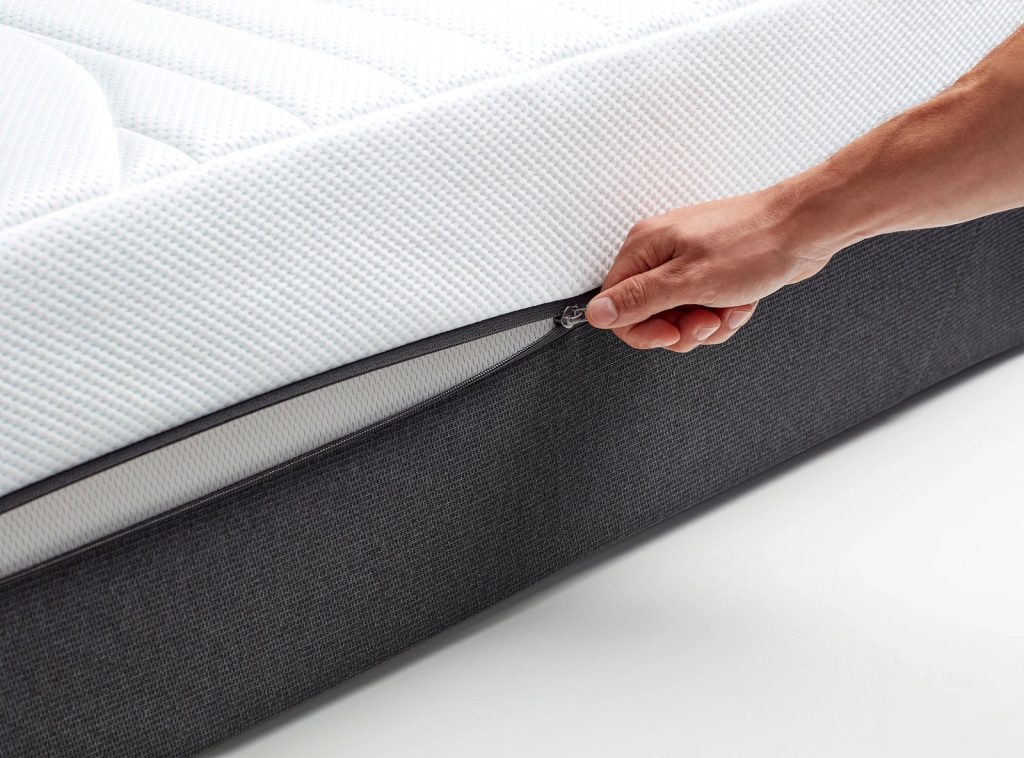 Colchão Tempur PRO Luxe CoolQuilt, mão a abrir o fecho da capa amovível