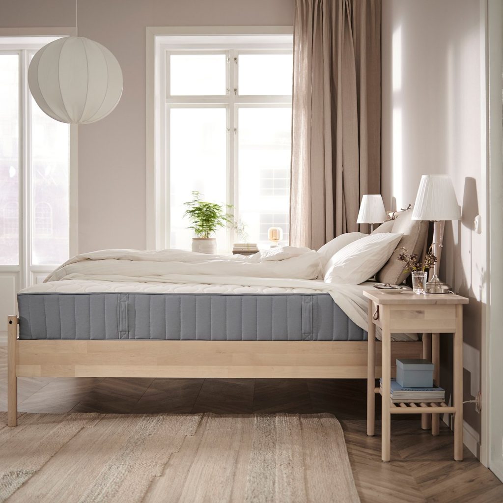 IKEA VÅGSTRANDA numa cama de madeira clara num quarto luminoso