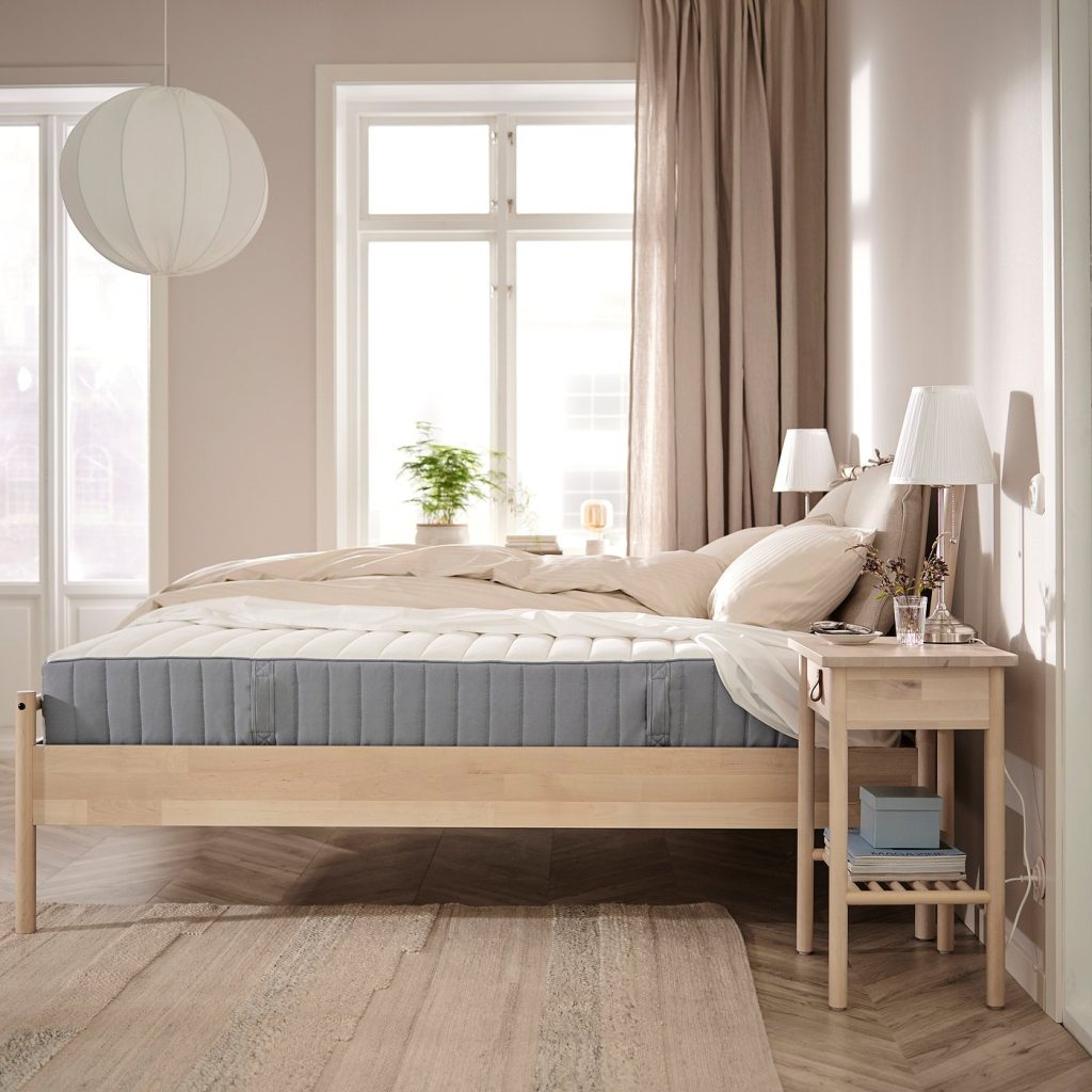IKEA VALEVÅG numa cama de madeira clara num quarto luminoso