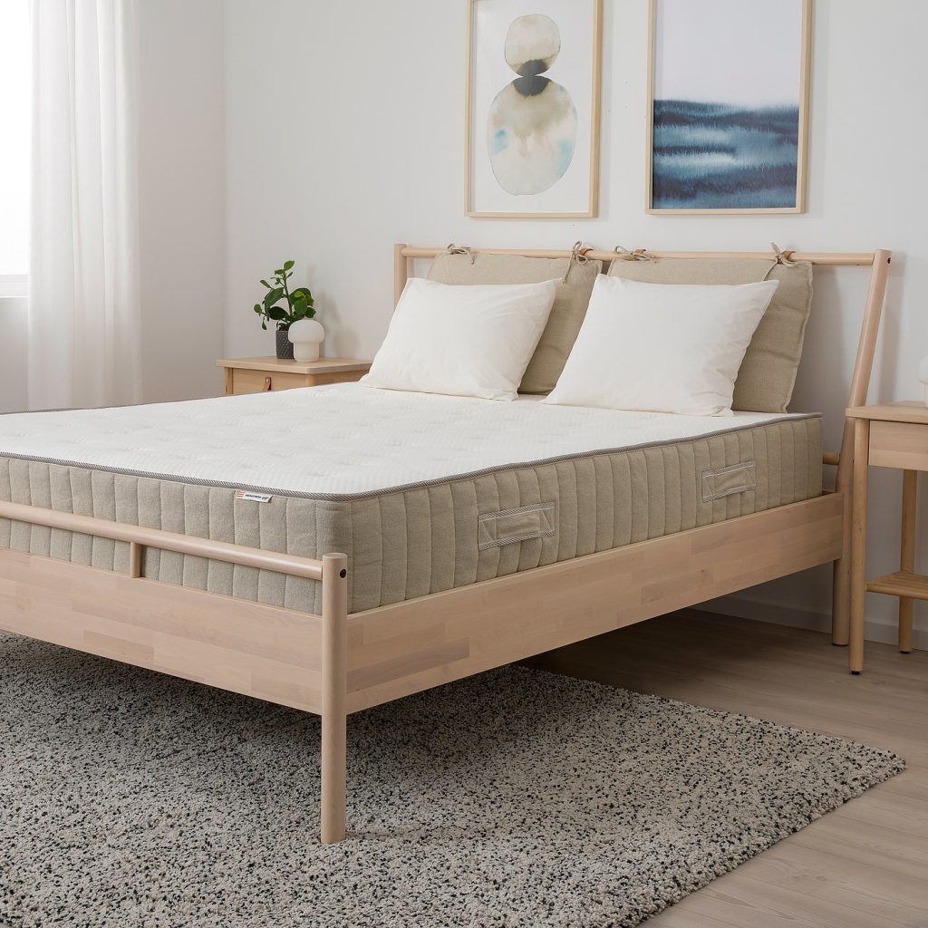 IKEA VATNESTRÖM numa cama de madeira clara num quarto com tapete