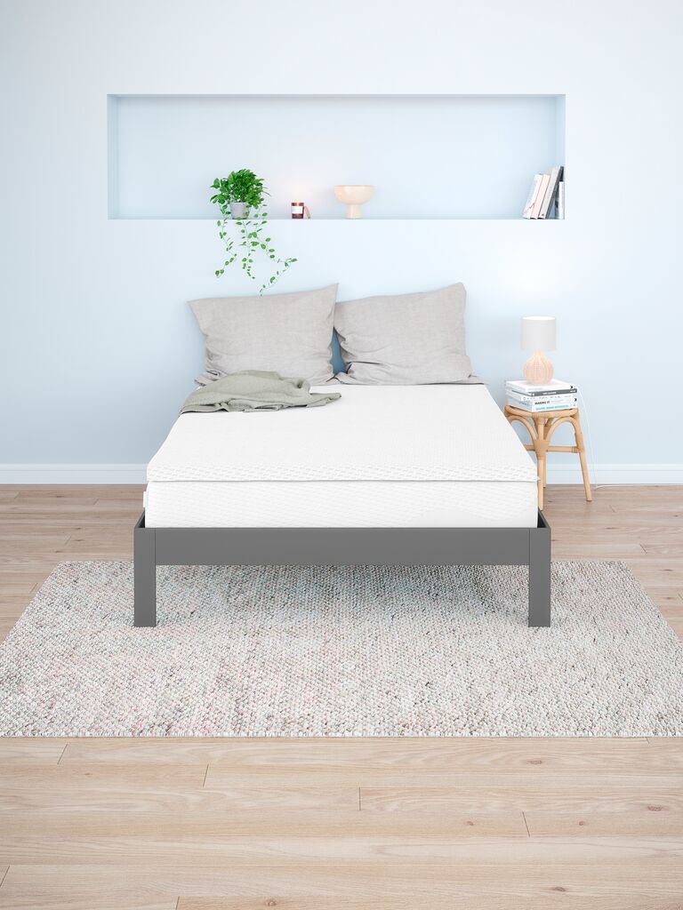 Wellpur Frya sobre um colchão numa cama de solteiro, num quarto claro