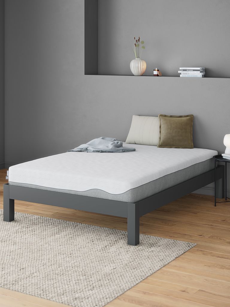 Colchão Wellpur Hovda numa cama de metal cinzenta num quarto com nicho na parede
