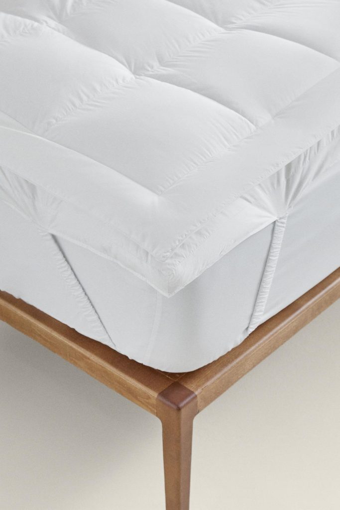 Canto do Topper de Colchão com Penugem da Zara Home com a fita elástica presa ao colchão