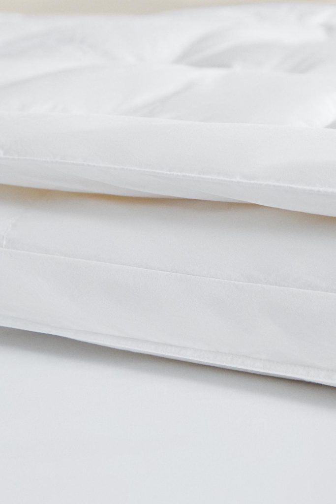 Lateral do Topper de Colchão com Penugem da Zara Home com o enchimento de 4 cm visível